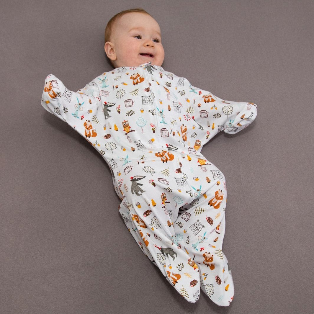 Baby liegt lächelnd im Bett