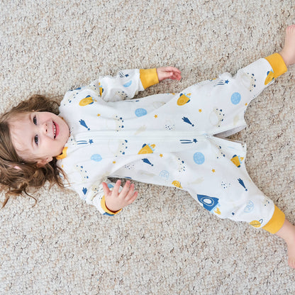 Kind liegt mit Schlafanzug auf dem Boden und lacht